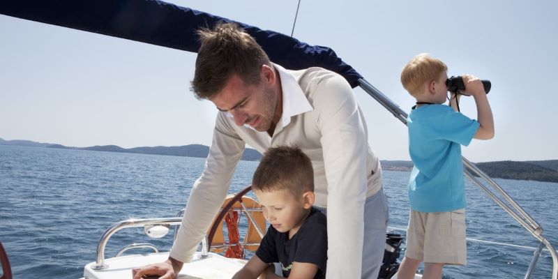 twee kinderen met hun vader op de boot