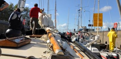 Een zeiler op z'n boot met op de achtergrond meerdere boten in het water